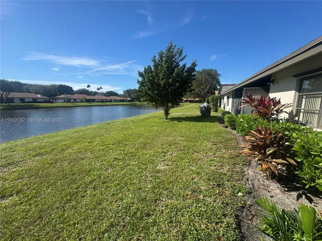 a view of a backyard with plants and lake view