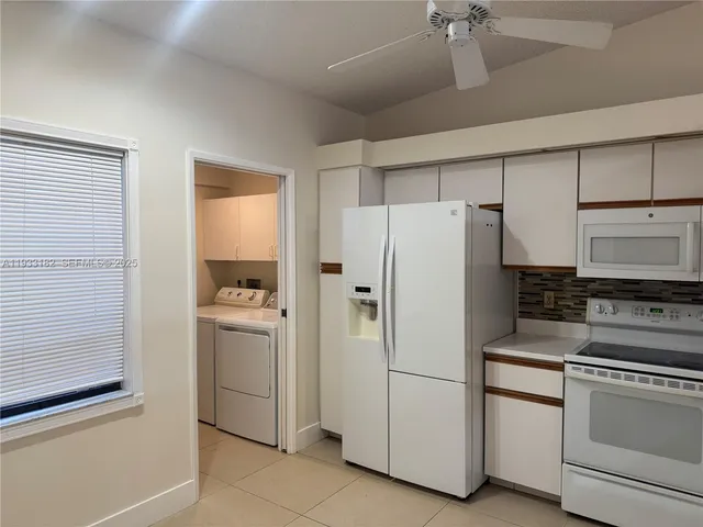a white refrigerator freezer and a stove sitting inside of a kitchen