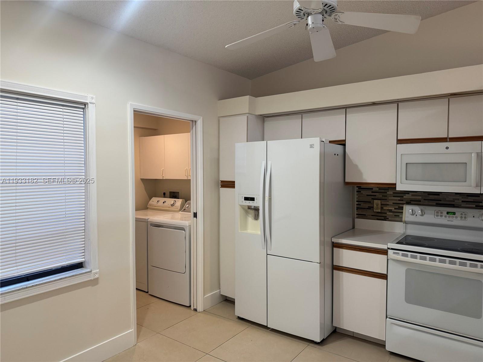 8200 Whispering Palm Drive, Unit F Boca Raton, FL 33496 - Photo 9 of 19 a white refrigerator freezer and a stove sitting inside of a kitchen