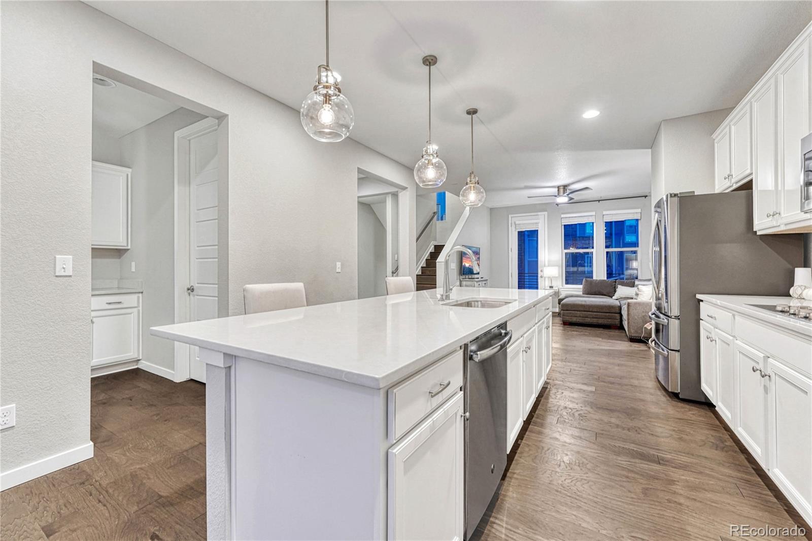8338 Rivulet Point Highlands Ranch, CO 80129 - Photo 1 of 46 a large kitchen with kitchen island a sink a counter space and stainless steel appliances