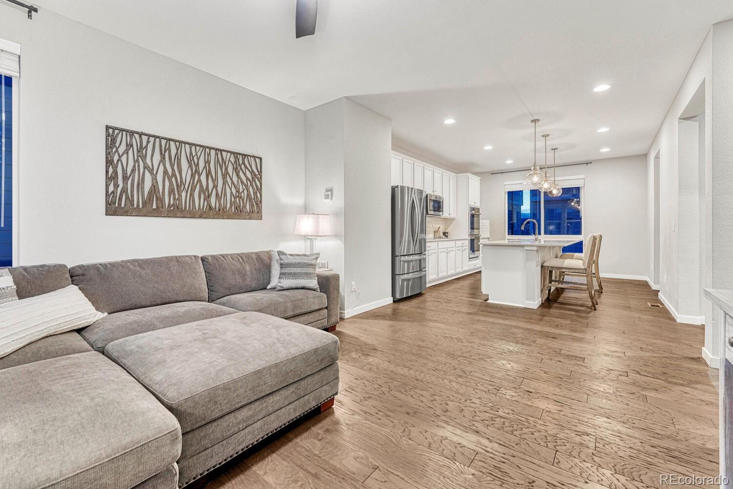 8338 Rivulet Point Highlands Ranch, CO 80129 - Photo 12 of 46 a living room with furniture and kitchen view with wooden floor