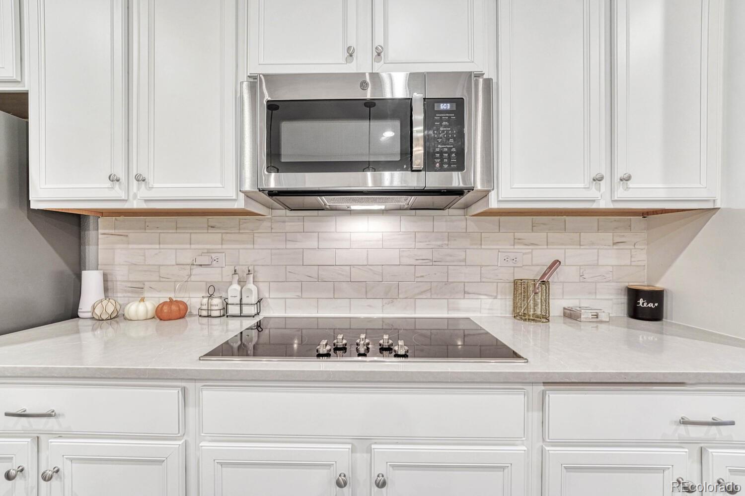 8338 Rivulet Point Highlands Ranch, CO 80129 - Photo 21 of 46 a kitchen with a microwave a sink and cabinets