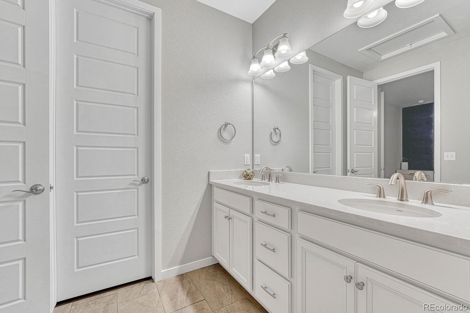 8338 Rivulet Point Highlands Ranch, CO 80129 - Photo 28 of 46 a bathroom with a double vanity sink and a mirror
