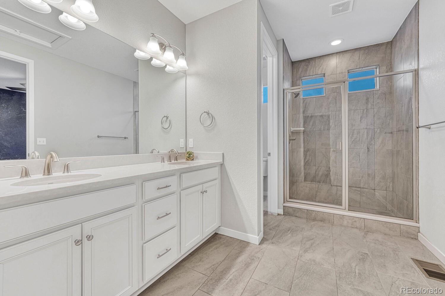 8338 Rivulet Point Highlands Ranch, CO 80129 - Photo 29 of 46 a spacious bathroom with a shower sink and mirror