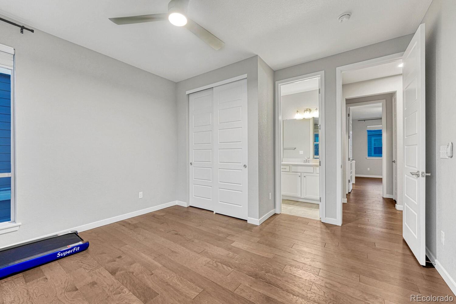8338 Rivulet Point Highlands Ranch, CO 80129 - Photo 31 of 46 a view of a room with wooden floor and white walls