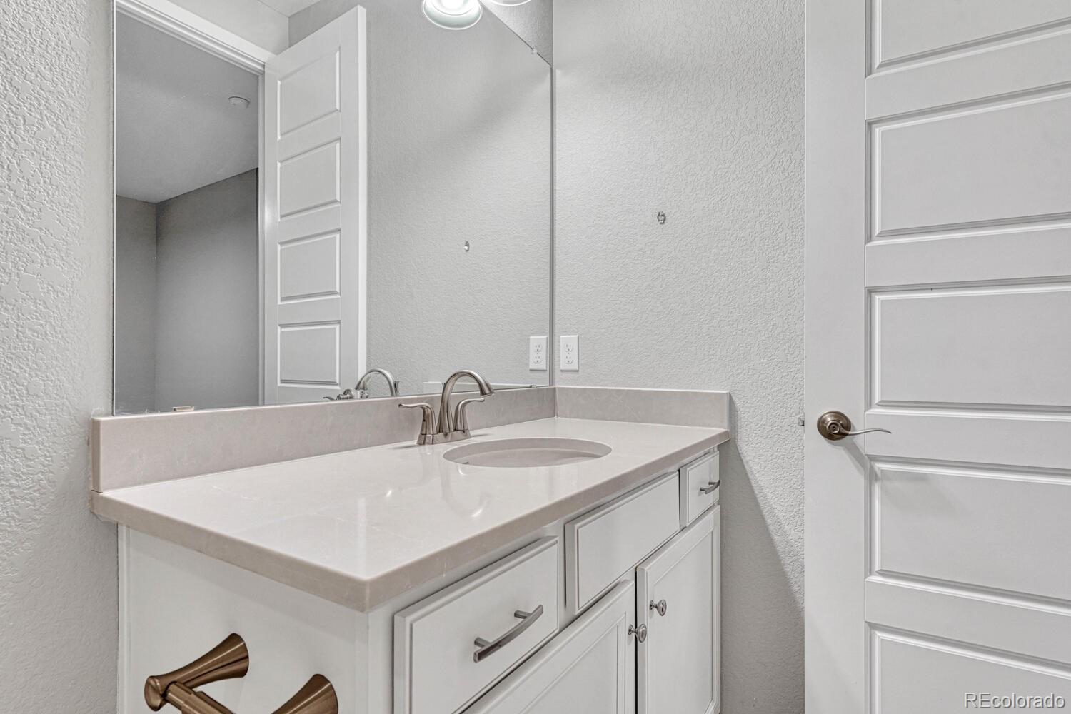 8338 Rivulet Point Highlands Ranch, CO 80129 - Photo 33 of 46 a bathroom with a sink and a mirror