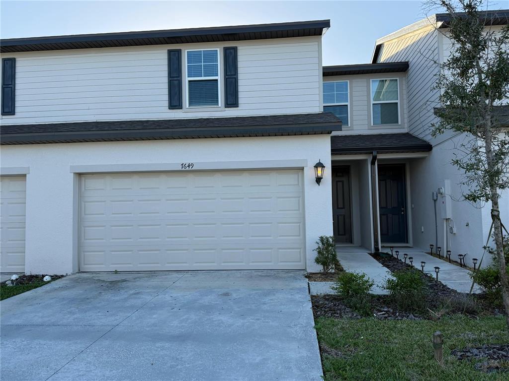 7649 Intrepid Road Wesley Chapel, FL 33545 - Photo 1 of 46 a front view of a house with garden