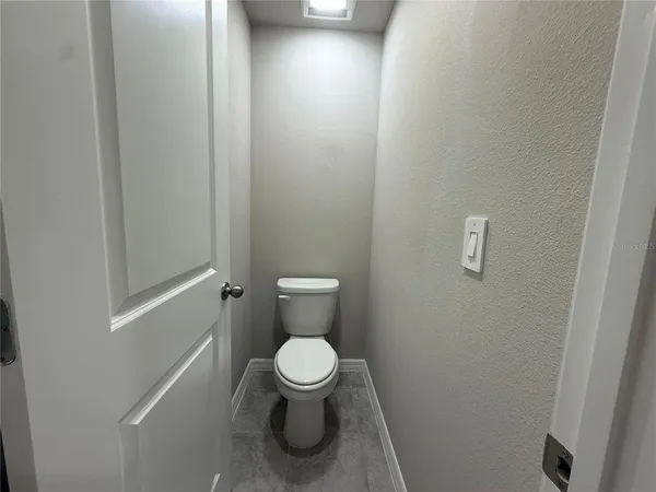a white toilet sitting next to a white cabinet
