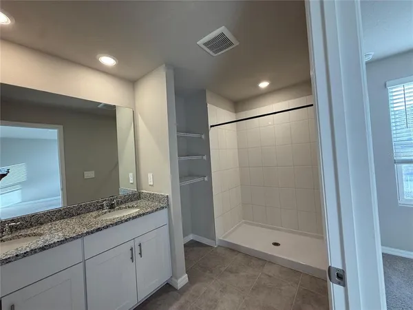 a bathroom with a granite countertop sink a shower and a mirror