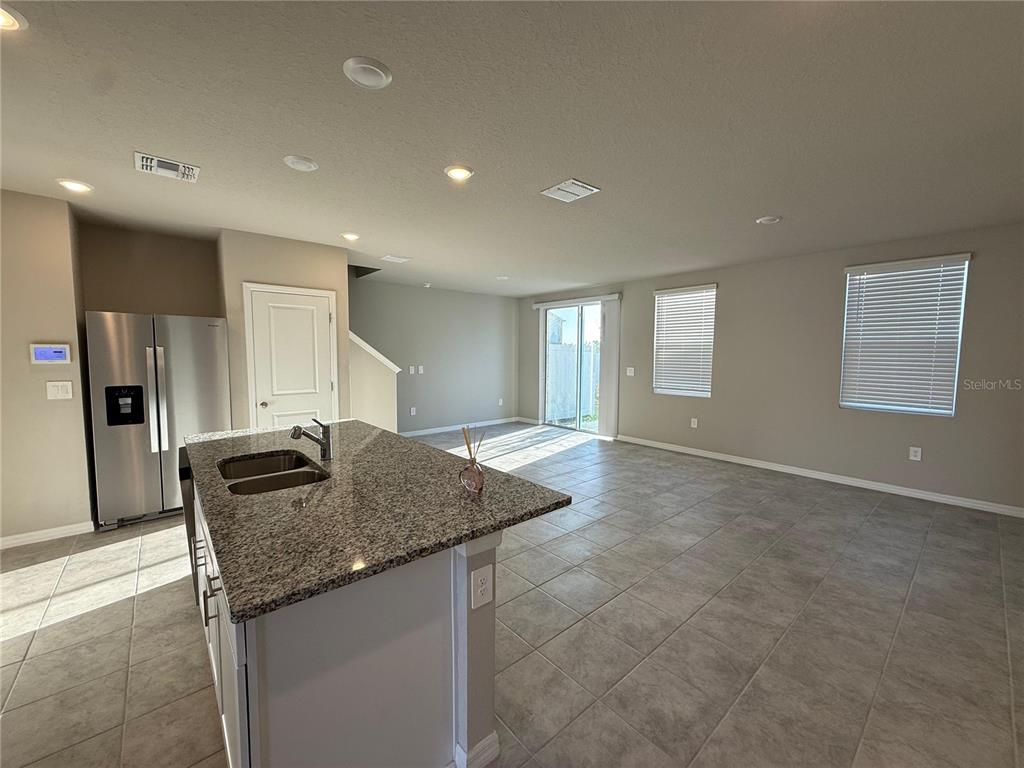 7649 Intrepid Road Wesley Chapel, FL 33545 - Photo 24 of 46 a kitchen with granite countertop a sink and a refrigerator