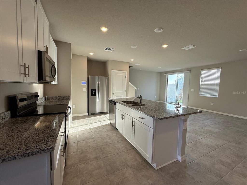 7649 Intrepid Road Wesley Chapel, FL 33545 - Photo 26 of 46 a large kitchen with stainless steel appliances granite countertop a stove oven and a sink with granite countertops