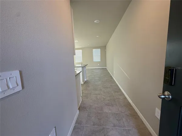 a view of a hallway with wooden floor and a bathroom
