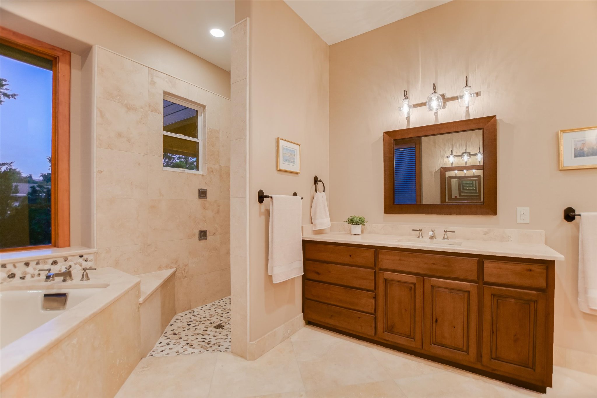 409 Venture Boulevard South Point Venture, TX 78645 - Photo 14 of 37 Bathroom featuring a built-in tub, tiled shower with pebble floor, wood-finish vanity with countertop, and framed mirror with integrated lighting