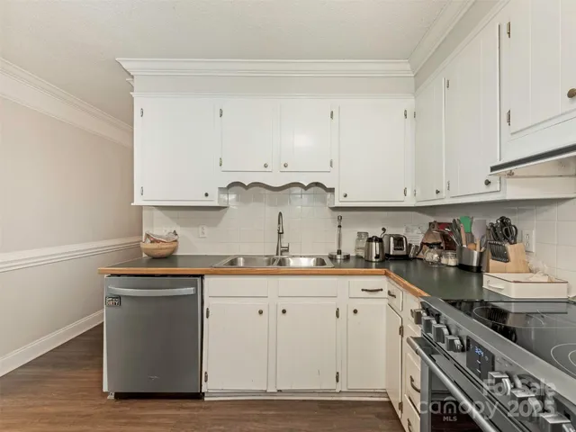 a kitchen with stainless steel appliances granite countertop a sink stove and cabinets