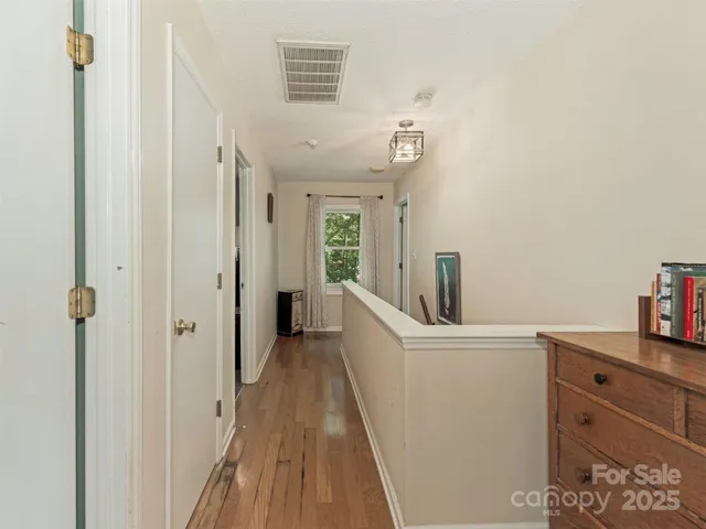 a view of a hallway with closet and wooden floor