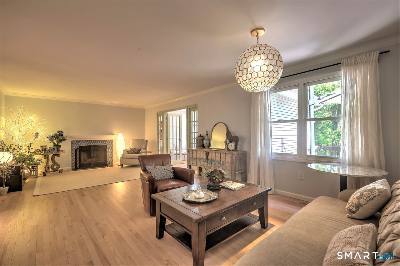 9 Canterbury Road, Unit 9 Hamden, CT 06514 - Photo 8 of 29 a living room with furniture a fireplace and a chandelier