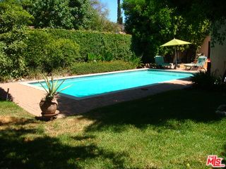 a view of a yard with table and chairs under an umbrella