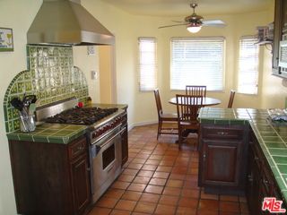 a kitchen with stainless steel appliances granite countertop a stove a refrigerator a dining table and chairs with wooden floor