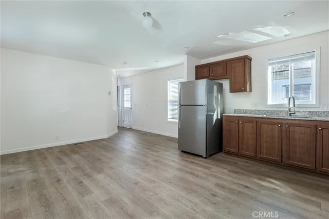 a kitchen with granite countertop a refrigerator and a sink