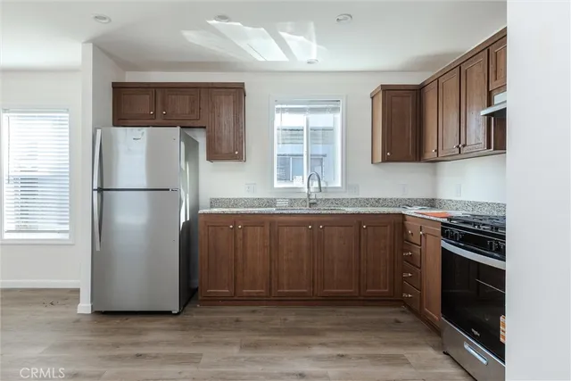 a kitchen with stainless steel appliances granite countertop a refrigerator sink and stove