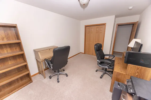 a view of a workspace with furniture and a window