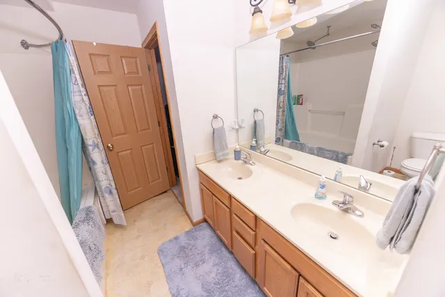 a bathroom with a double vanity sink a mirror and a shower