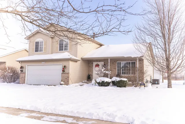 a view of a house with a yard covered in snow