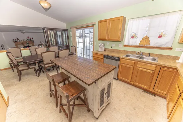 a living room with a table chairs and a refrigerator