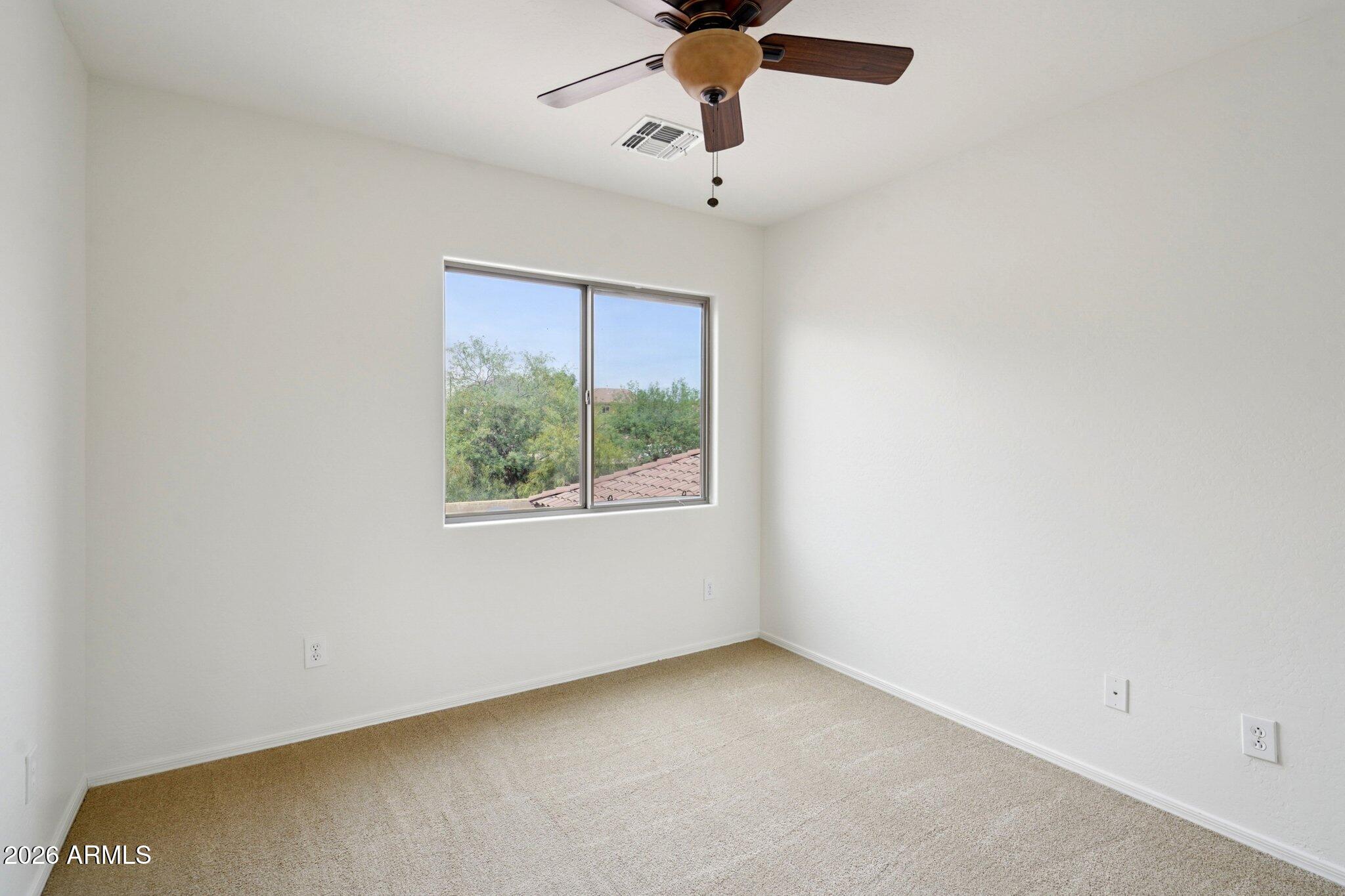 3852 West Ranier Court Anthem, AZ 85086 - Photo 27 of 58 an empty room with a window and a ceiling fan