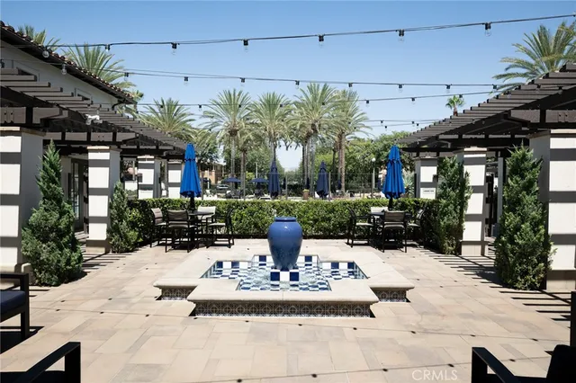 a view of swimming pool with outdoor seating and palm trees