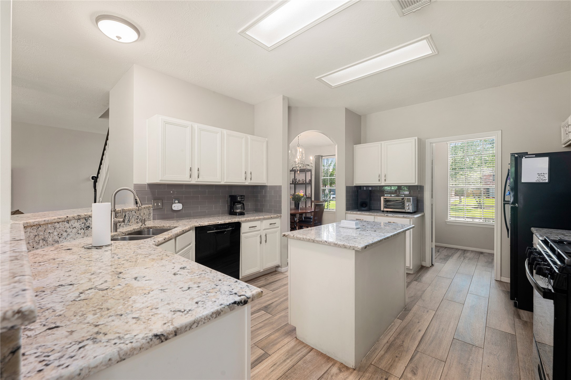 19726 Teller Boulevard Spring, TX 77388 - Photo 6 of 24 This chef's dream kitchen is as functional as it is beautiful, offering a bright and airy workspace for all your culinary adventures. Boasting crisp white cabinetry, stunning granite countertops, and a central island, there is no shortage of prep space or storage.