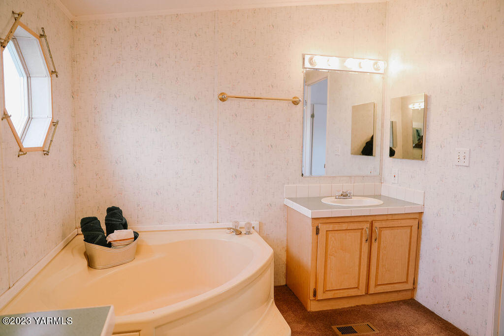 151 Rougk Lane Sunnyside, WA 98944 - Photo 32 of 43 a bathroom with a tub sink and mirror