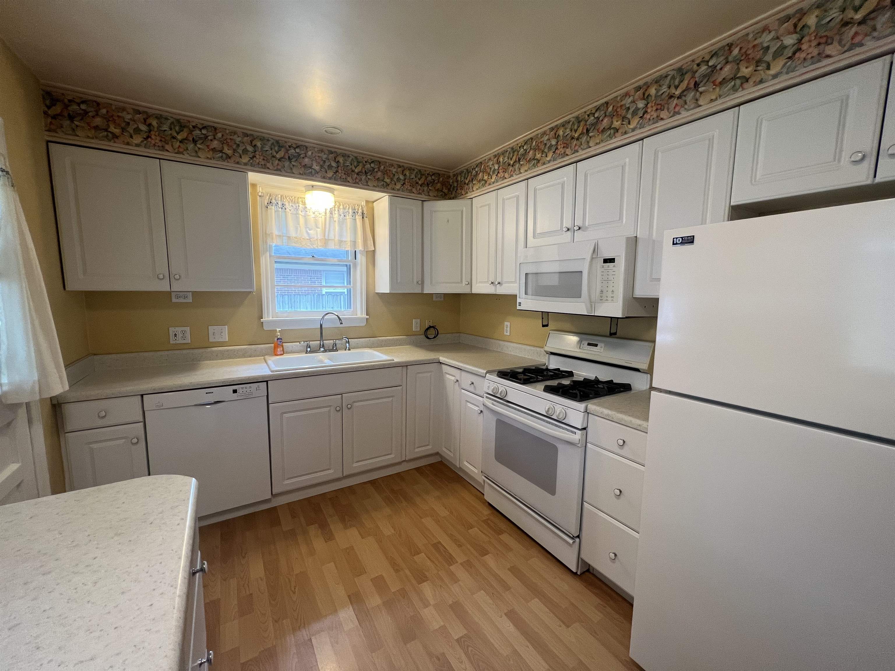 1048 West Perkins Road Memphis, TN 38117 - Photo 4 of 15 a kitchen with a sink stove and white cabinets