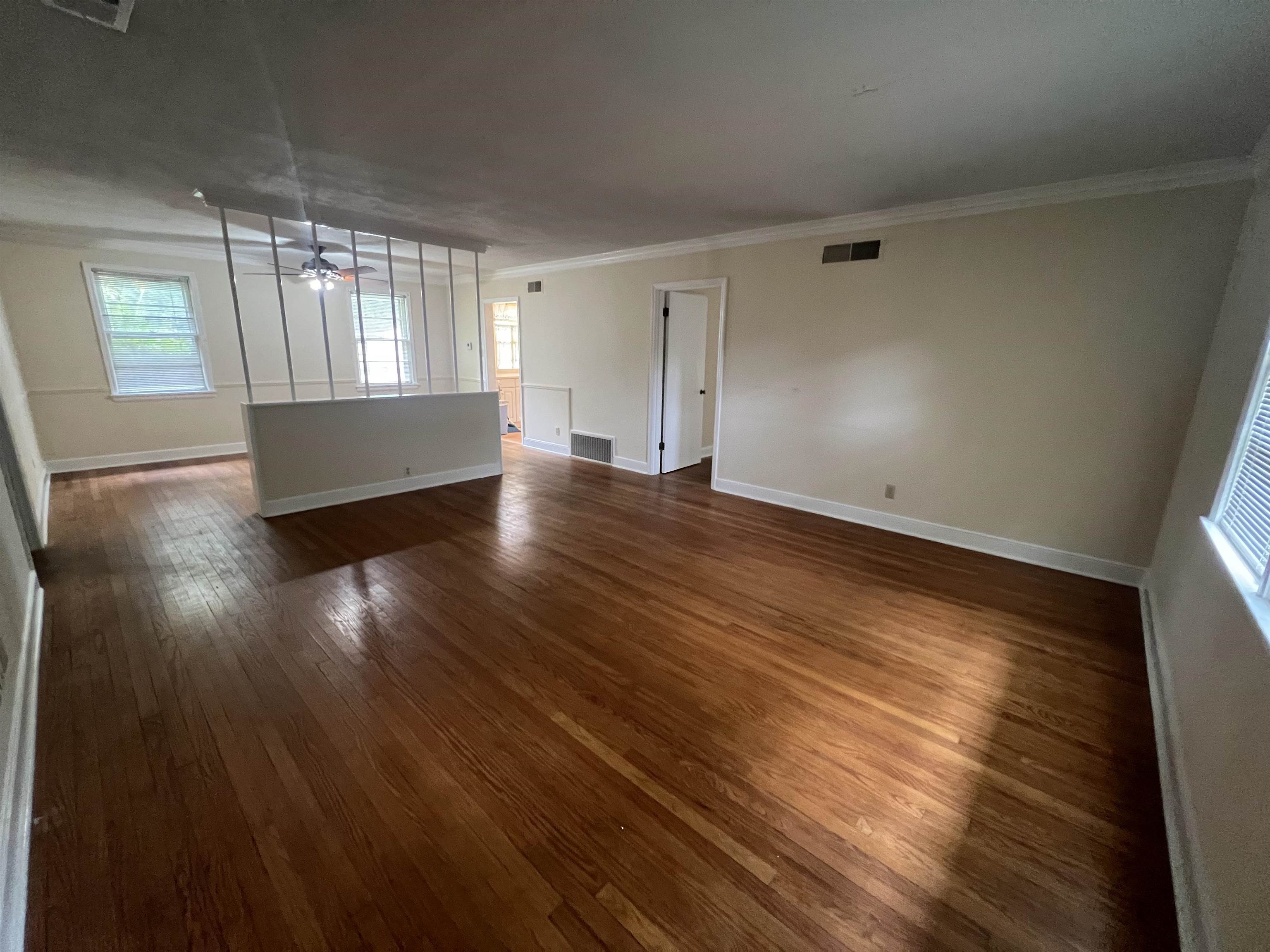 1048 West Perkins Road Memphis, TN 38117 - Photo 8 of 15 an empty room with wooden floor and windows