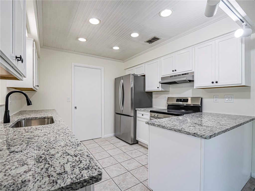 1331 Barber Street Sebastian, FL 32958 - Photo 8 of 32 a kitchen with stainless steel appliances granite countertop a sink stove and refrigerator