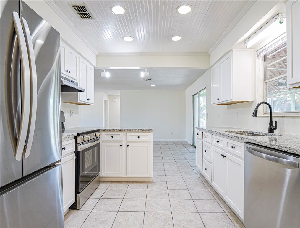 1331 Barber Street Sebastian, FL 32958 - Photo 10 of 32 a kitchen with stainless steel appliances granite countertop a refrigerator sink and stove