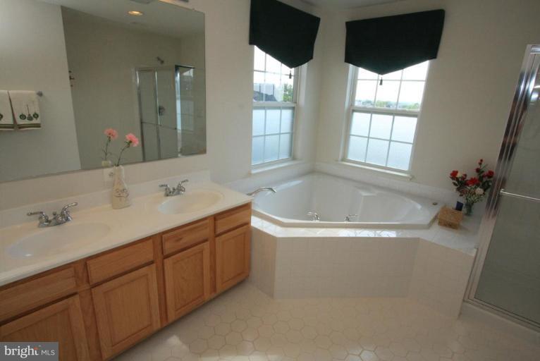 18604 Broken Oak Road Boyds, MD 20841 - Photo 14 of 18 a bathroom with a tub sink and mirror