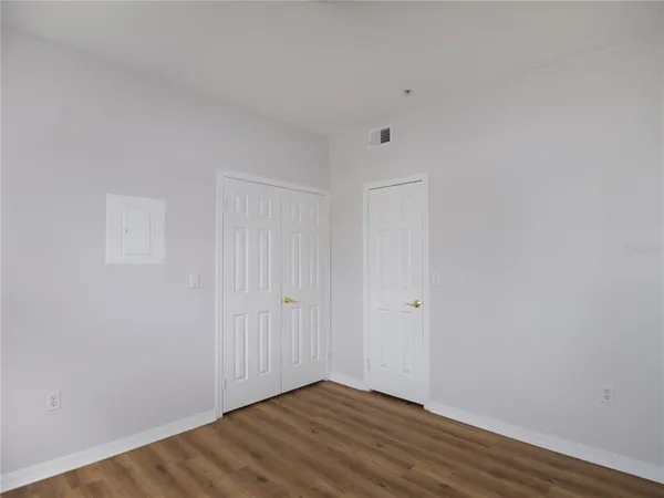 a view of an empty room with wooden floor