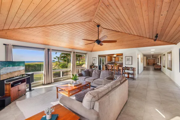 a living room with furniture and a open kitchen view