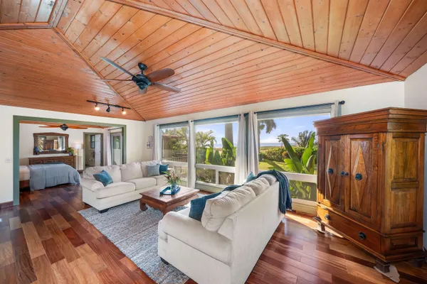 a living room with furniture a ceiling fan and a rug