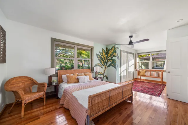 a bedroom with a large bed and windows