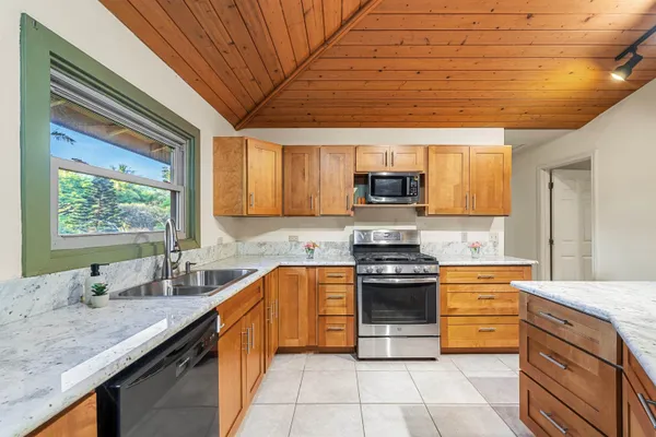 a kitchen with stainless steel appliances granite countertop a stove sink and cabinets