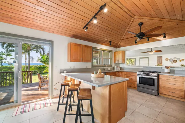 a kitchen with stainless steel appliances granite countertop a stove top oven a sink dishwasher and chairs with wooden floor