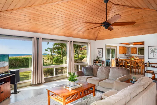 a living room with furniture and a open kitchen view