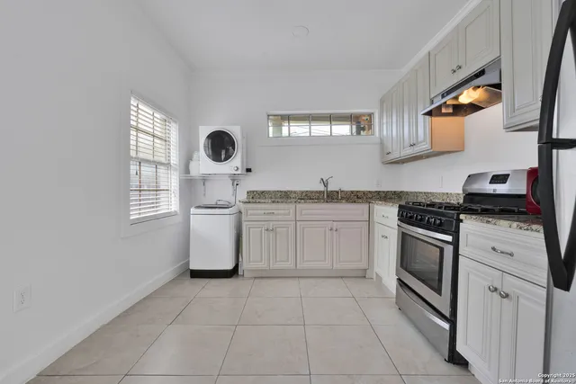 a kitchen with a stove sink and cabinets