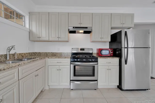 a kitchen with white cabinets and white appliances
