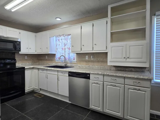a kitchen with granite countertop cabinets and white appliances