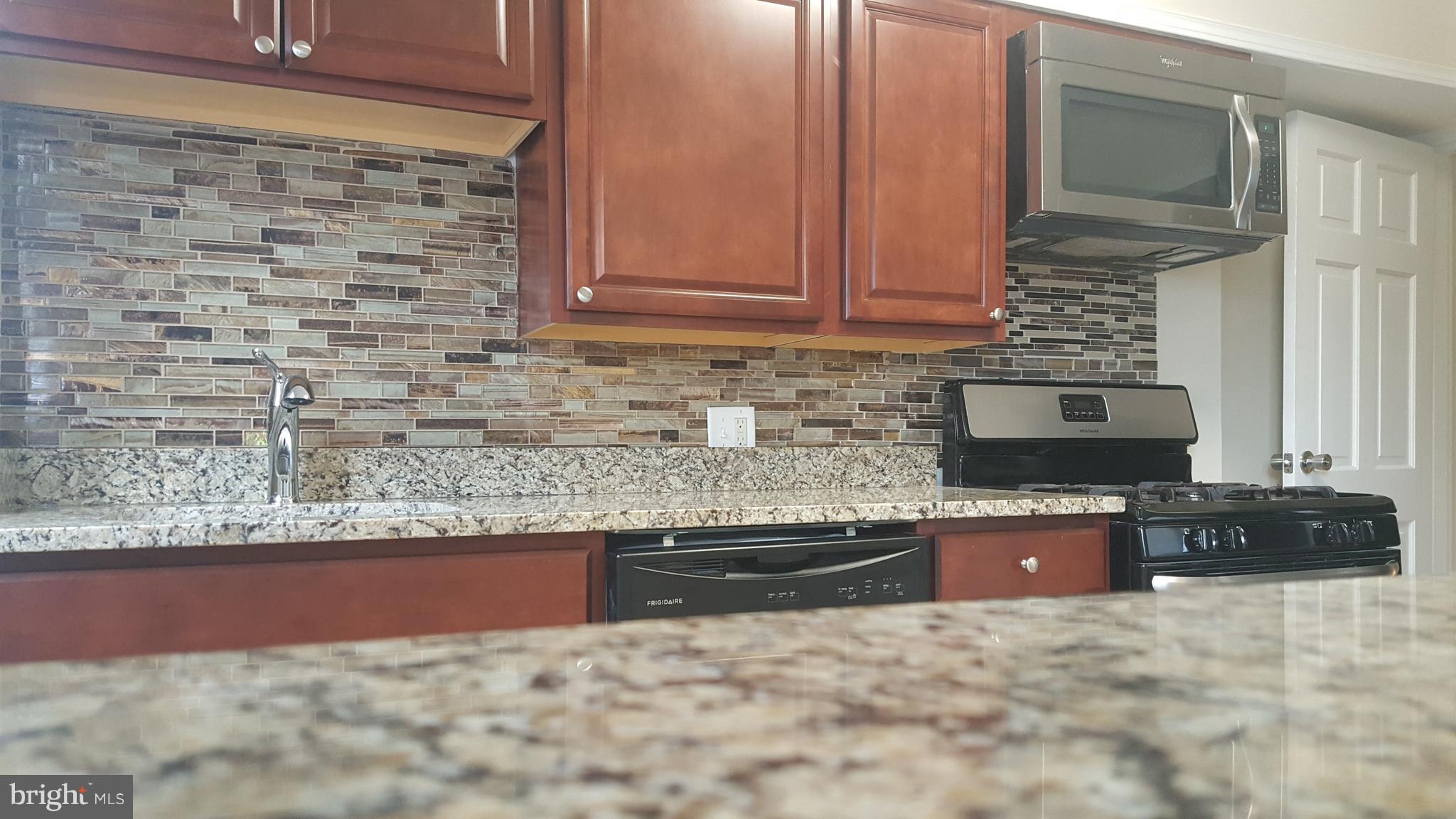 642 Brisbane Road Baltimore, MD 21229 - Photo 1 of 16 a kitchen with granite countertop a sink and a stove top oven
