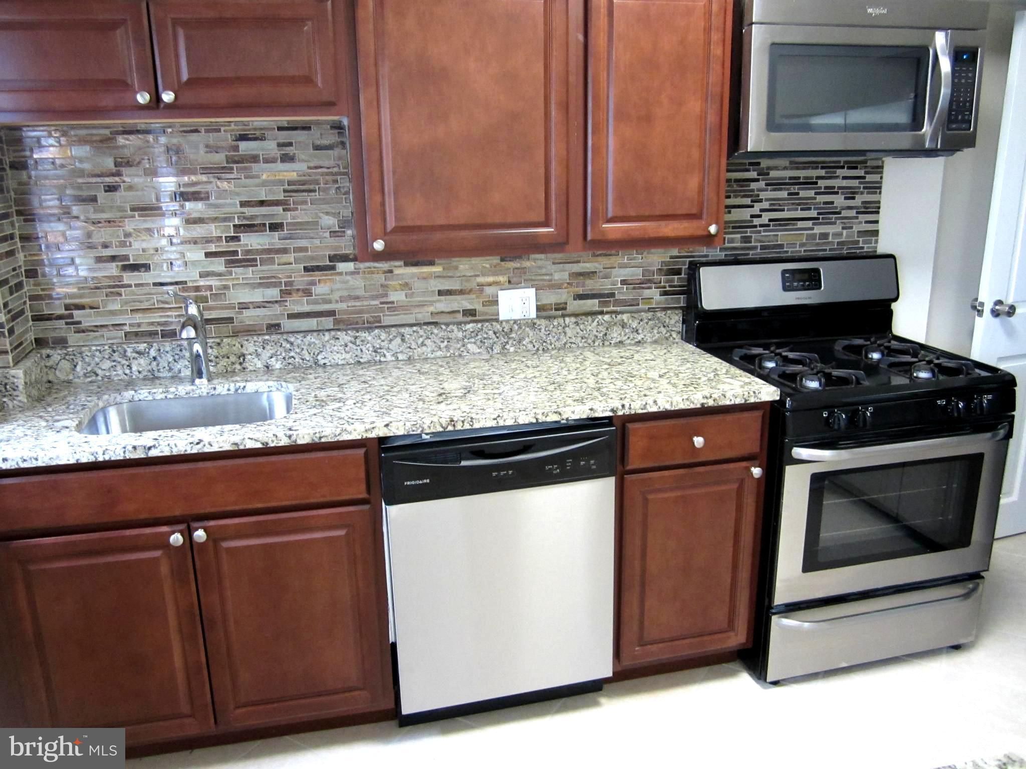 642 Brisbane Road Baltimore, MD 21229 - Photo 4 of 16 a kitchen with granite countertop a stove and a sink