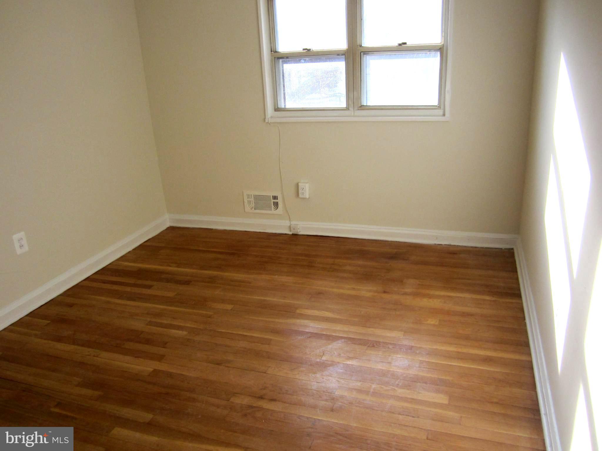 642 Brisbane Road Baltimore, MD 21229 - Photo 7 of 16 an empty room with wooden floor and windows
